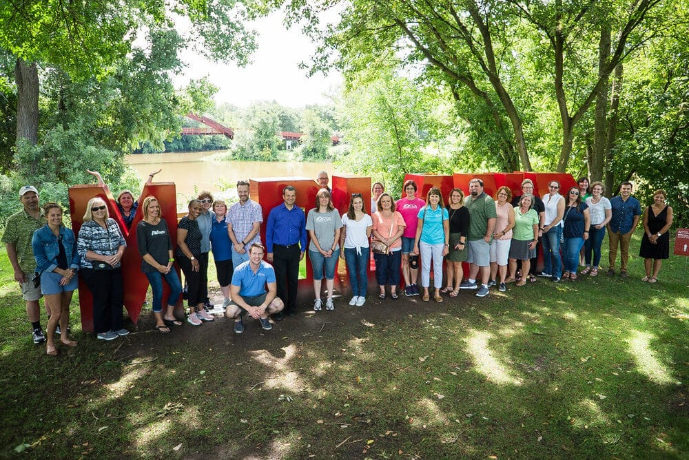 Members of the Midland Area Community Foundation post next to a large